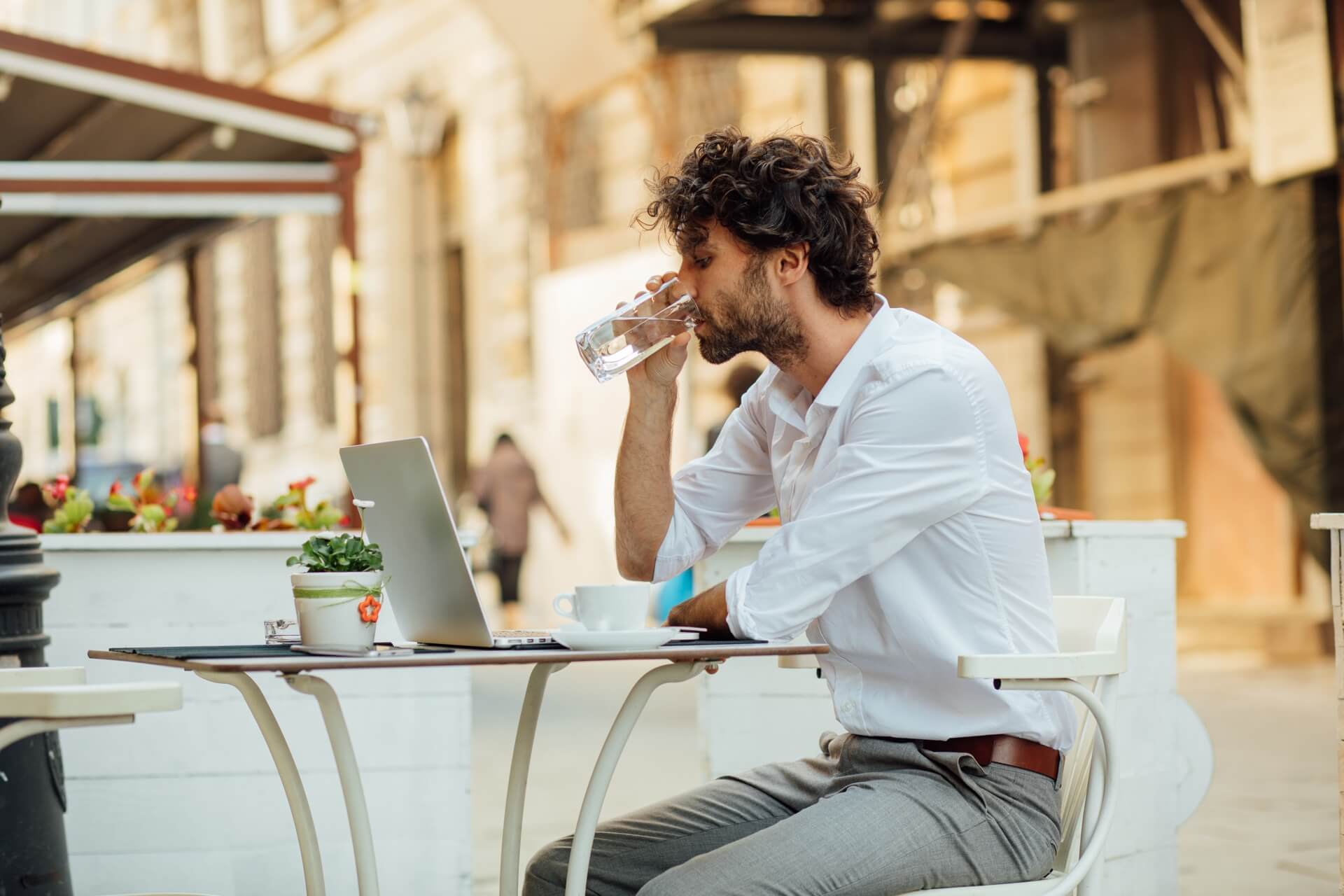 Photo with a man sitting at the terrace and working